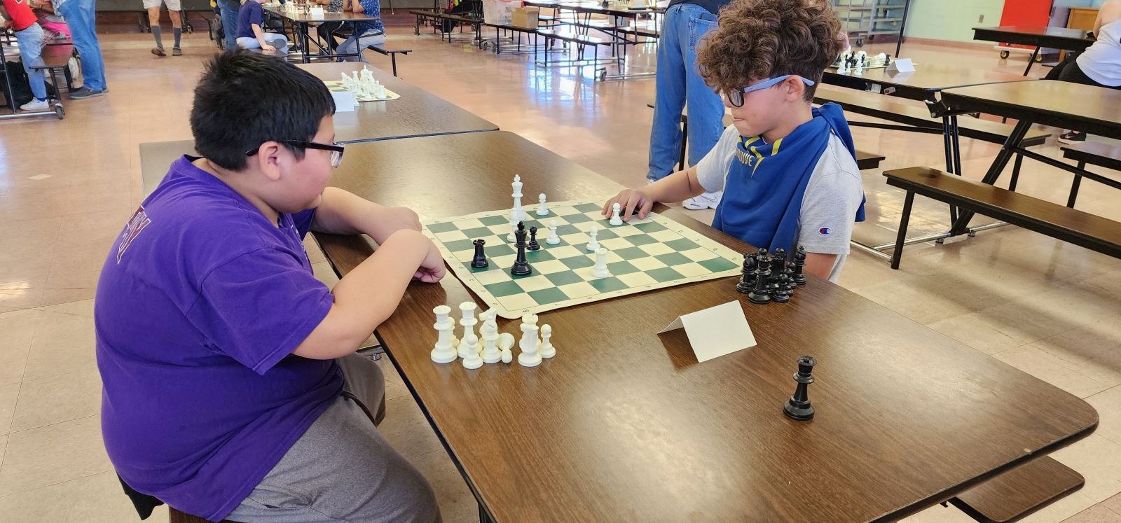 Two boys in glasses play chess