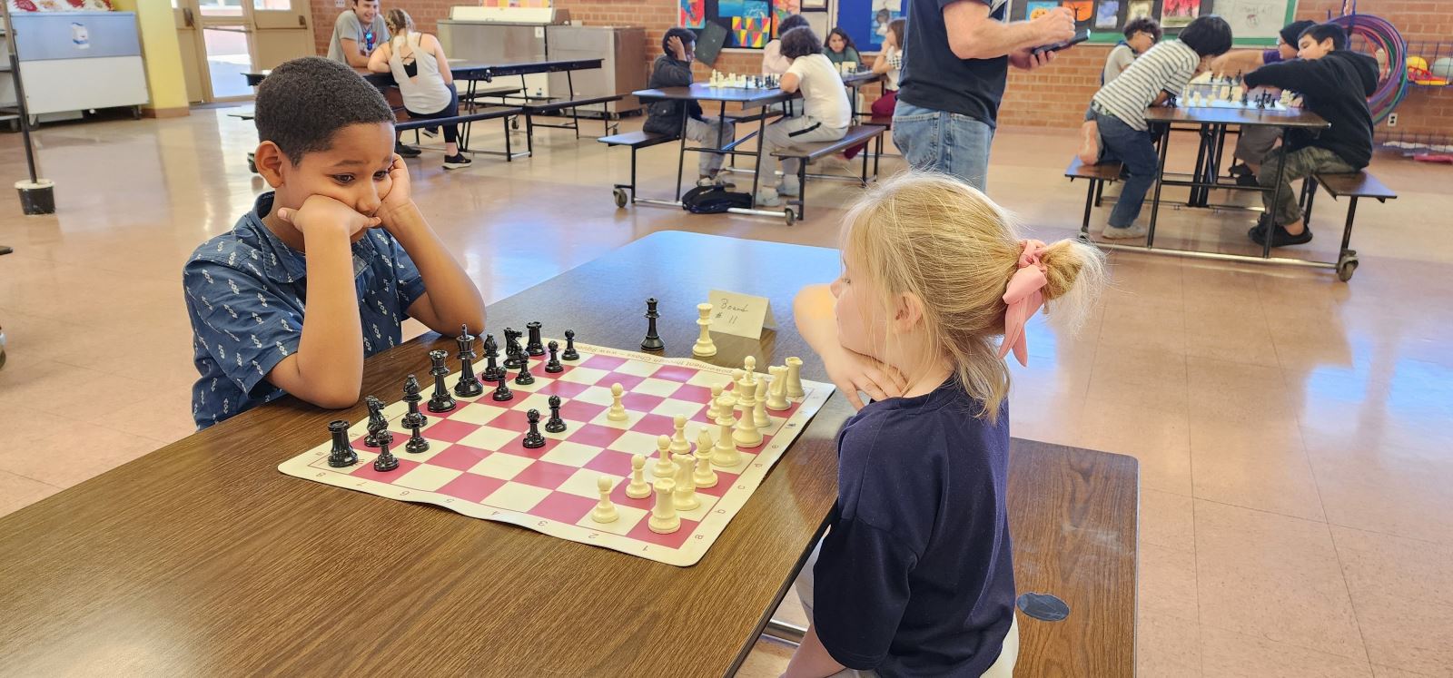 A boy and a girl play chess