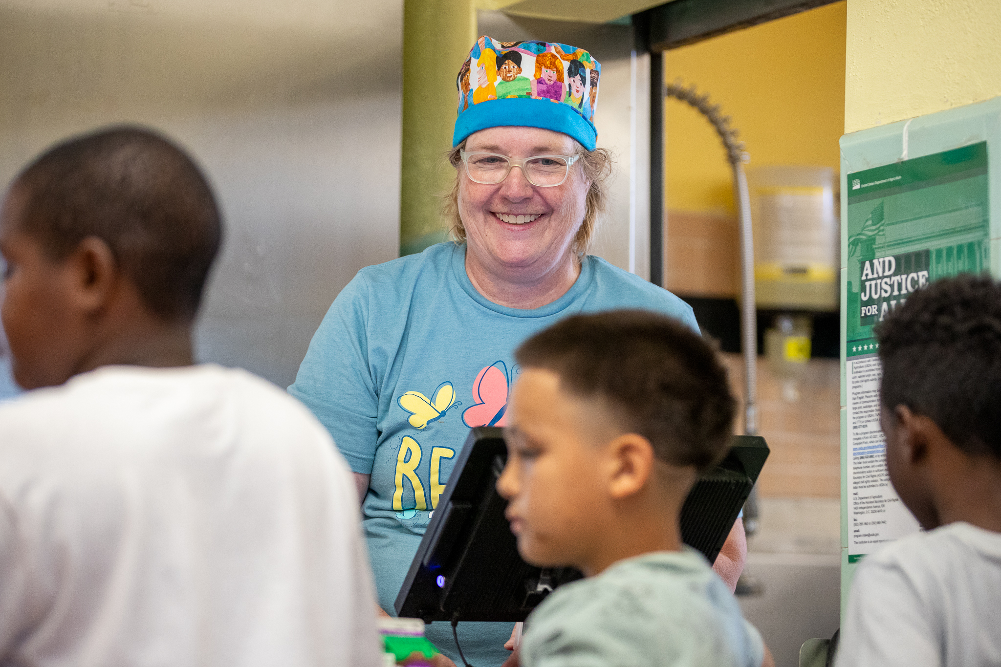 A Food Services employee smiles as she rings up students at the cash register