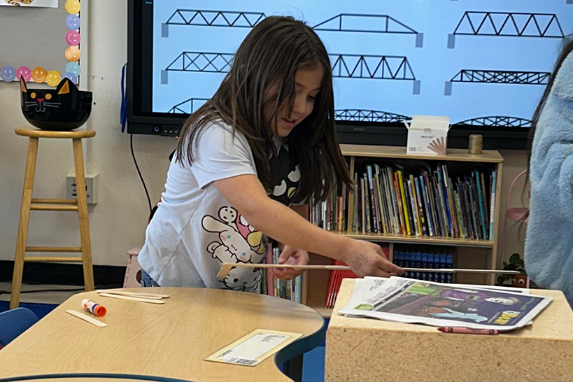 A girl measures the distance between desks
