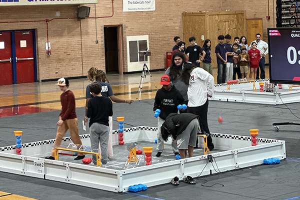 Students stand inside the robotics course setup