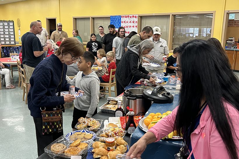 Students and parents stand in line to get food