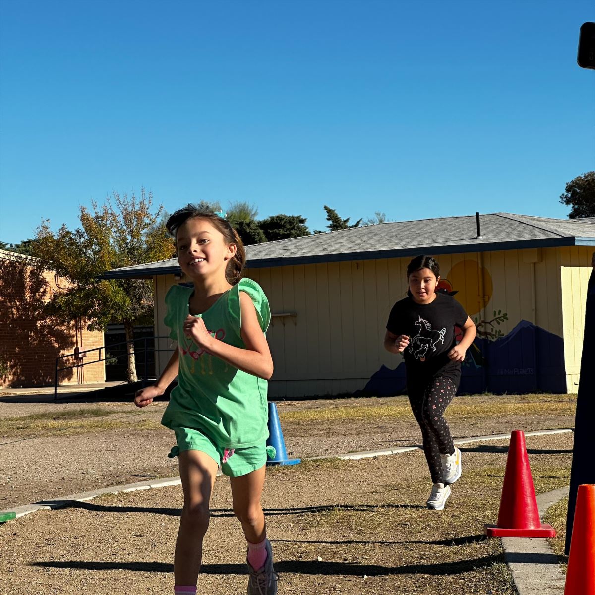 Two girls smile while running the Turkey Trot.